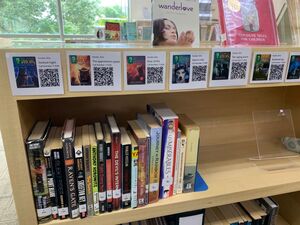 bookshelves with qr codes for digital books attached above